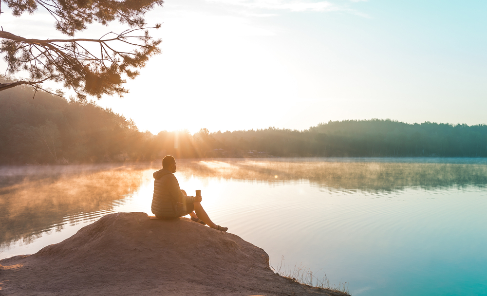 Man meditating near Michigan lake